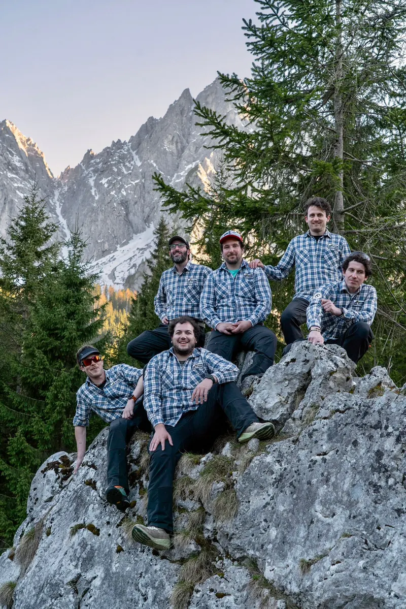 I Plodar Bergsteiger su una roccia davanti alle montagne di Sappada