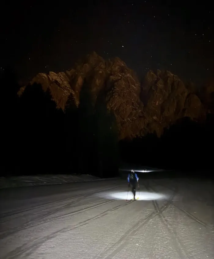 Uno scialpinista con la frontale e il Siera sullo sfondo